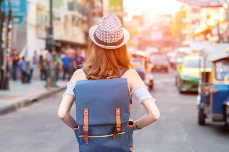 dziewczyna z niebieskim plecakiem, podróżująca po mieście