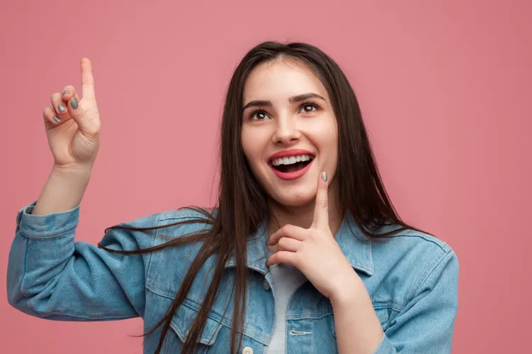 uśmiechnięta kobieta podnosi palec 