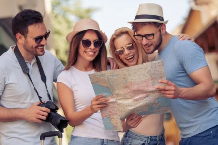 grupa wesołych ludzi ogląda mapę 