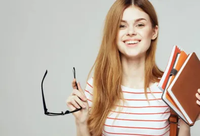 dziewczyna z okularami i zeszytami w ręku