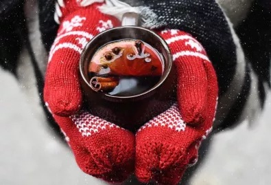 grzane wino w dłoniach w ciepłych rękawicach 
