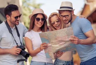 grupa wesołych ludzi ogląda mapę 